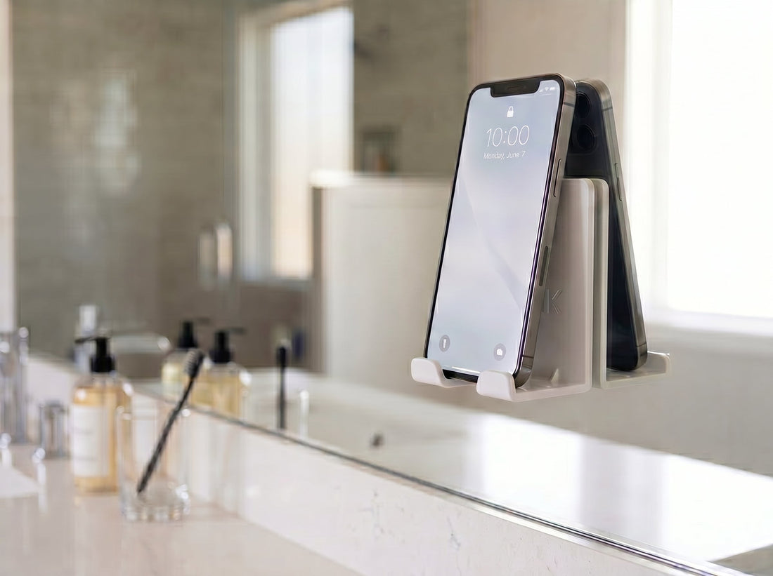 AIRSTIK white nano-suction phone cradle on a bathroom mirror holding a phone hands-free
